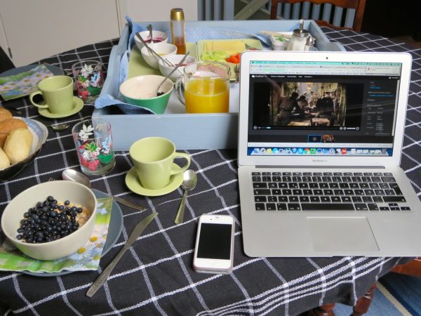 Gedeckter Frühstückstisch mit Laptop und Handy