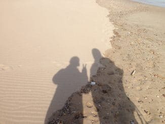 Zwei menschliche Schatten im Sand